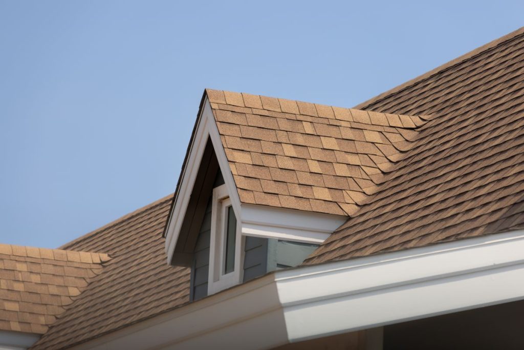 Roof shingles with garret house on top of the house, dark brown asphalt tiles on the roof, St Paul