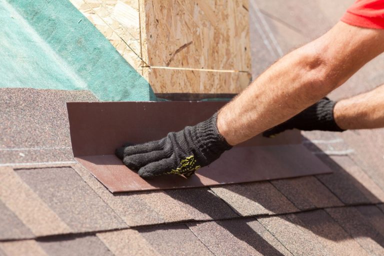 Roofer builder worker installing shingles on a new wooden roof with skylight, St Paul, MN
